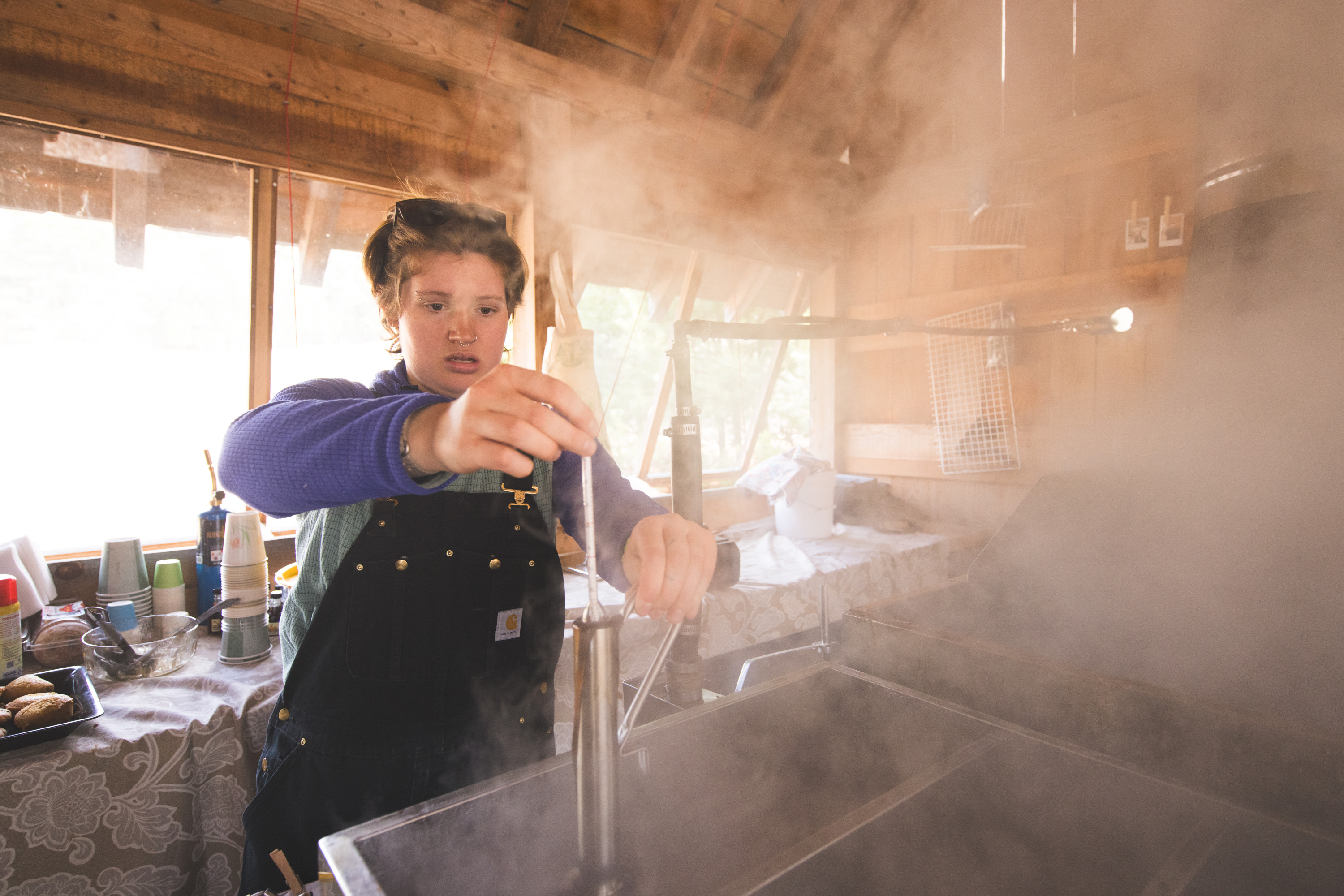 Student makes syrup in the sugar shack