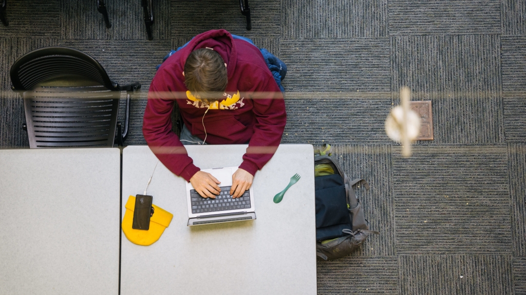 Student typing at a laptop